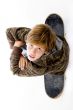top view of boy sitting on skateboard