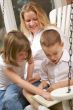 Young Boy Reads to His Mother and Sister