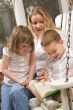 Young Boy Reads to His Mother and Sister