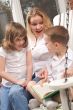 Young Boy Reads to His Mother and Sister