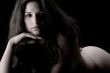 naked brunette in a low key setting thinking