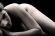 naked brunette in a low key setting resting