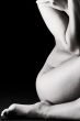 Body parts of a naked woman in a low key setting