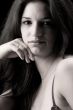 Lingery dressed brunette in a low key setting making eye-contact