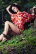 beautiful girl sitting on grass in beautiful and colourful dress