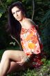 beautiful girl sitting on grass in beautiful and colourful dress