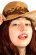 Young woman in hat shows tongue