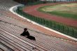 one man sitting alone in stadium grandstand