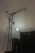 Gray sunset sky with lifting construction cranes