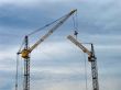 Sunset cloudy sky with lifting cranes