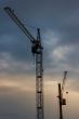Sunset cloudy sky with lifting cranes