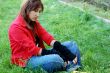young woman sitting on grass, sad expression
