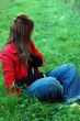pretty woman sitting on grass playing with hairs