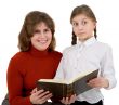 Woman with girl reading book