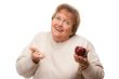 Confused Senior Woman Holding Apple and Vitamins
