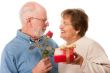 Happy Senior Couple with Gift and Red Rose