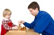 Man and child play chess