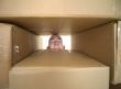 Face looking trough window in pile cardboard boxes