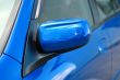 Right side mirror of shiny blue car