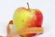 apple and measuring tape isolated on white background