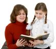 Woman and girl reading book