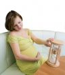 Pregnant woman looking on the hourglass