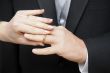 Bride slipping ring on finger of groom