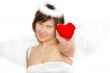 Young woman in angel`s costume with red heart