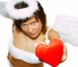 Young woman at angel`s costume with red heart