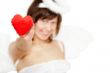 Young woman in angel`s costume with red heart