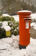 Traditional red British Post box in the snow