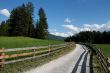 Alpine countryside road among meadows