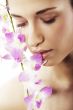 Beautiful young woman with orchid flowers