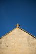 stone cross at top of church