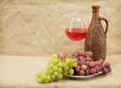 Ceramic brown bottle, grapes and goblet