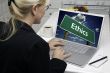 Woman In Kitchen Using Laptop