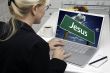 Woman In Kitchen Using Laptop