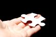 Hand holding a puzzle piece