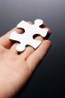 Hand holding a puzzle piece