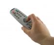 Hand holding a TV remote control isolated over white