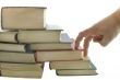 Stack of books and fingers step isolated on the white background