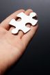 Hand holding a puzzle piece
