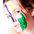 Teenage girl with four colors of paint on her face