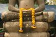 Sitting Buddha with yellow flowers in hands