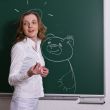 Young woman is standing at the blackboard