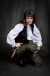 Girl - pirate with pistol sit on black