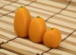 Three fresh kumquat against a mat