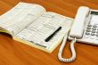 White telephone on wooden desk.