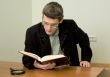 Guy in eyeglasses reads the book