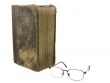 Glasses near very old bible on the white background